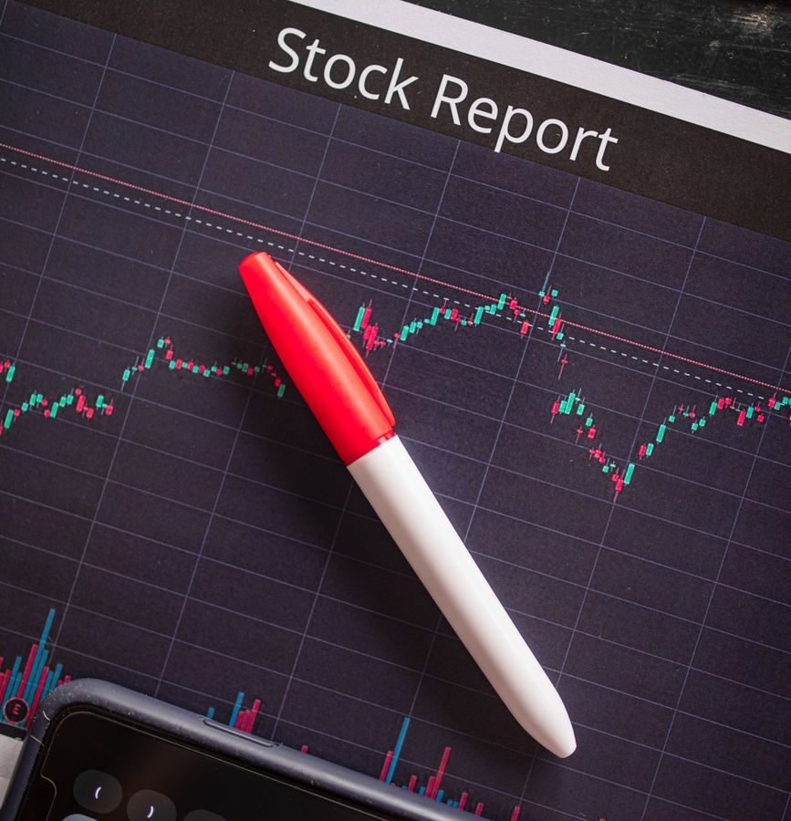 close up shot of a pen on a paper with stock report